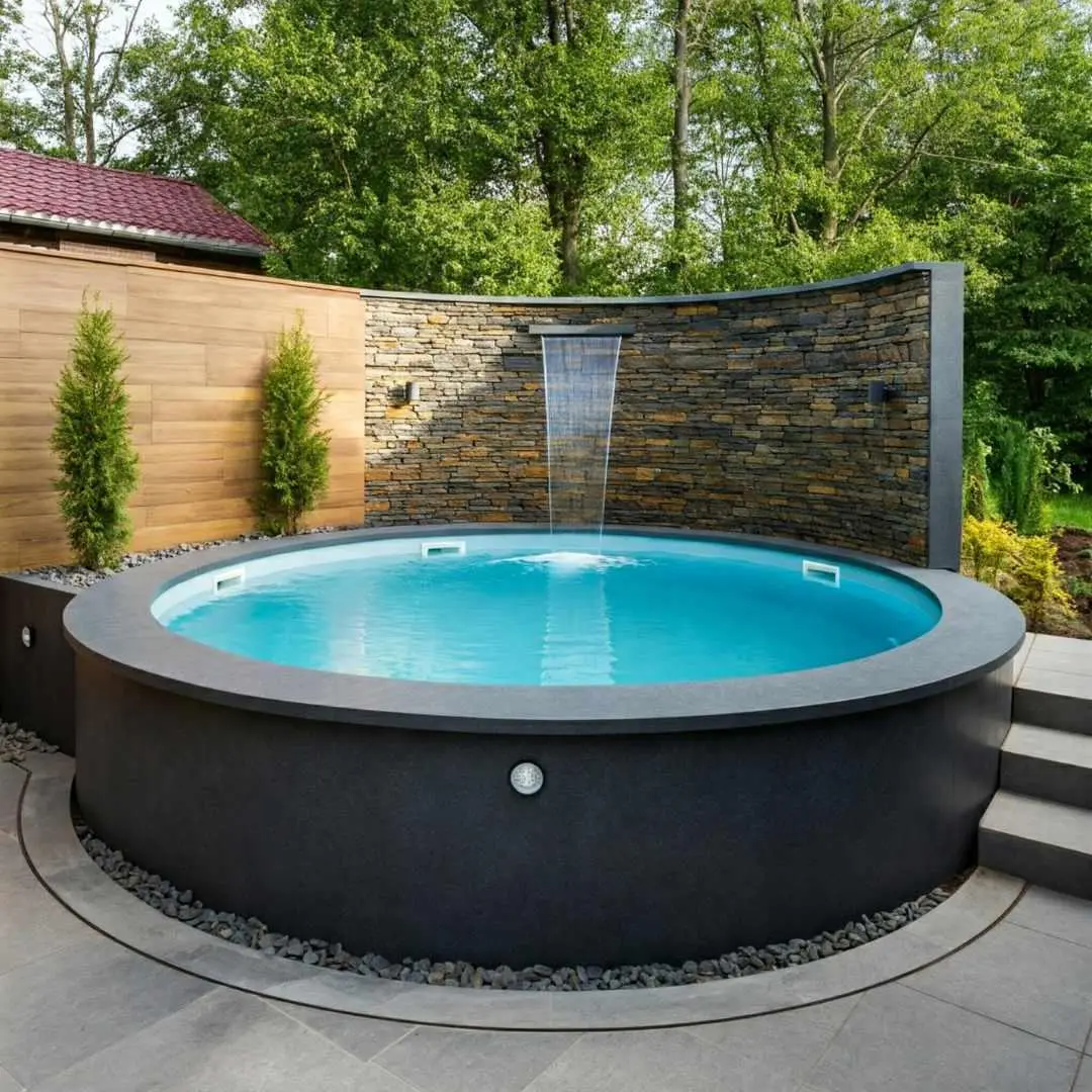 Round above-ground plunge pool with curved stone wall and waterfall feature in landscaped backyard