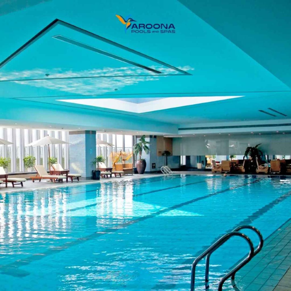 Indoor custom lap swimming pool with lounge chairs and large windows inside a luxury aquatic facility in Mosman, NSW.