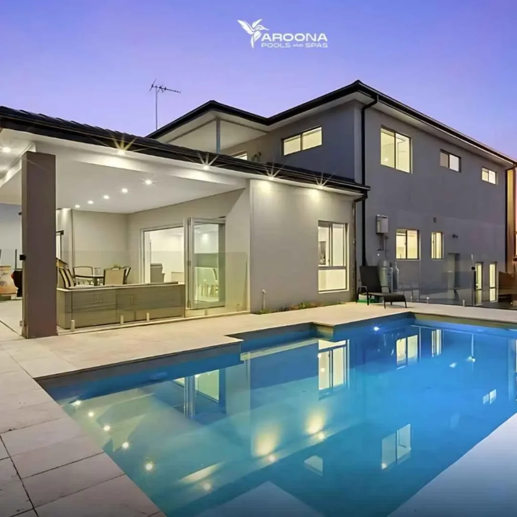 Modern luxury swimming pool at night with LED lighting and contemporary home design
