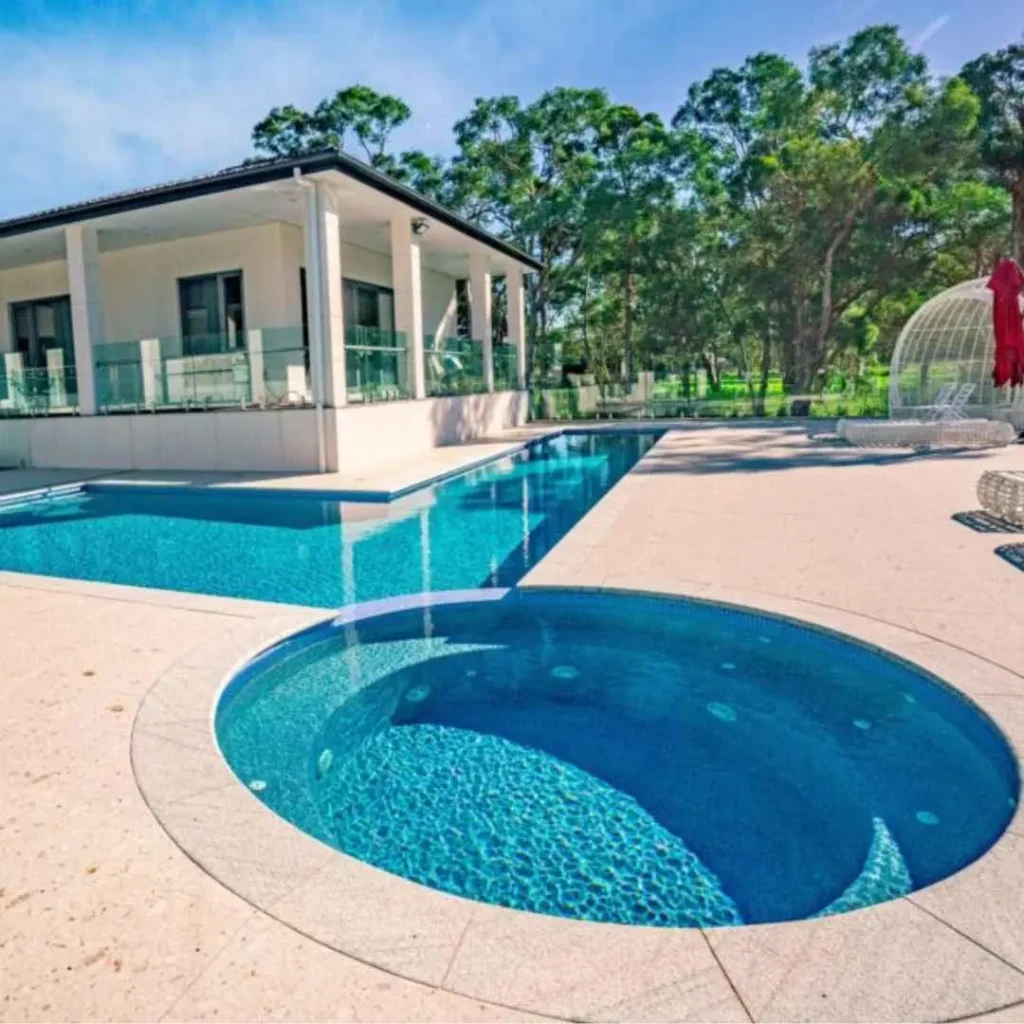 Luxury backyard pool with curved spa, modern home design, and landscaped surroundings in Castle Cove NSW