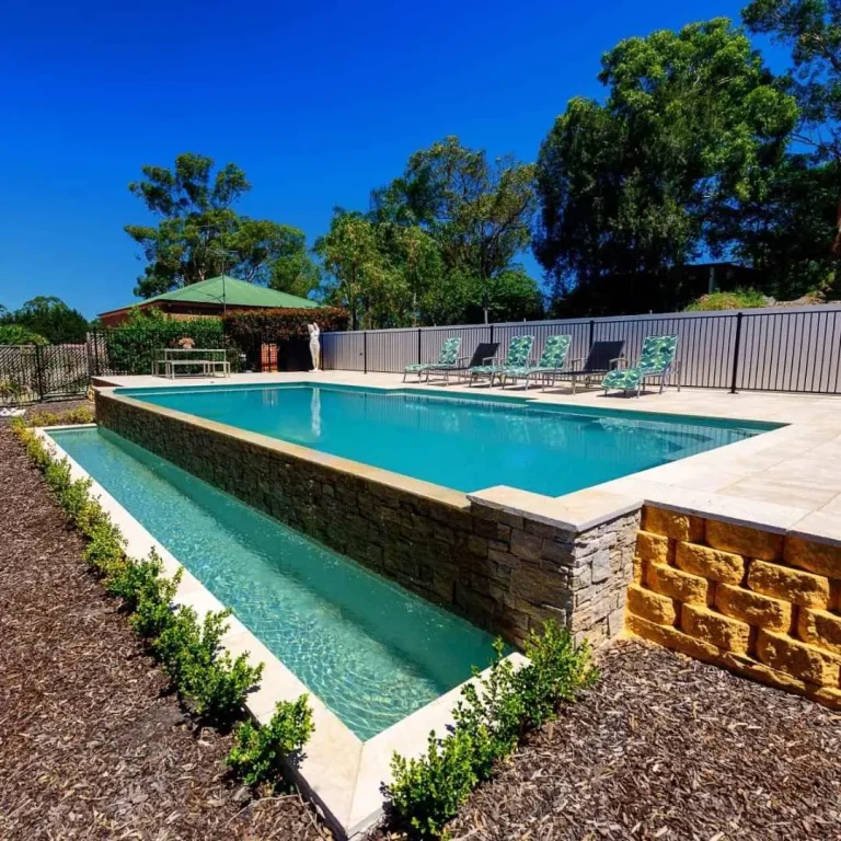Elevated custom lap pool with stone retaining wall and surrounding landscaped garden in Castle Hill NSW