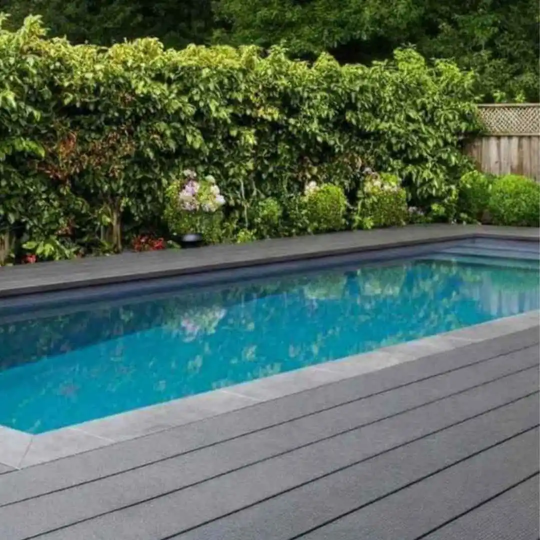 Rectangular precast plunge pool with timber deck and lush green privacy hedge in a modern backyard in Mosman, NSW.